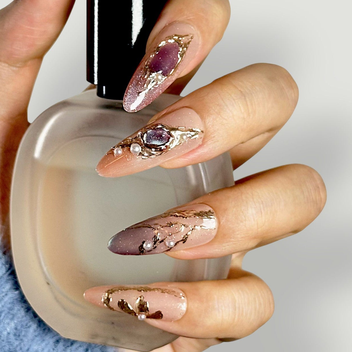 Side profile of Velvetkay Gilded Mirage nails, highlighting the golden accents and Almond silhouette.