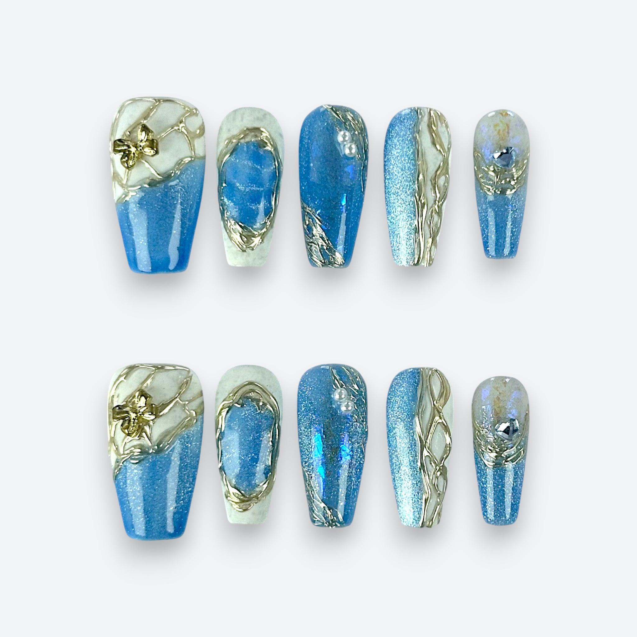 Full set layout of Velvetkay Glacier Sonata press-on nails in Coffin shape. Icy blue premium design.