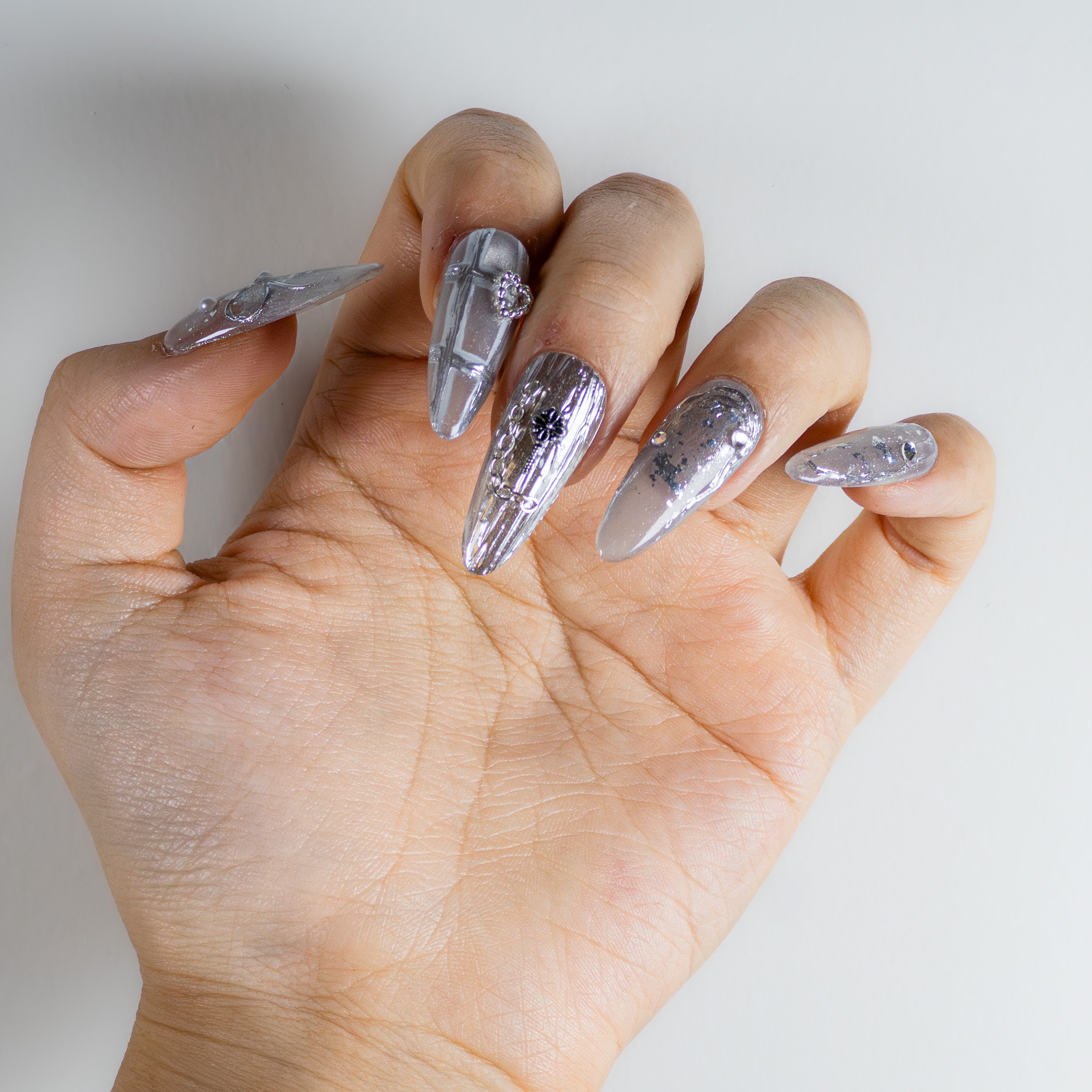 Molten silver chrome with 3D gothic chains and sculpted liquid metal details on durable salon-grade structure gel.