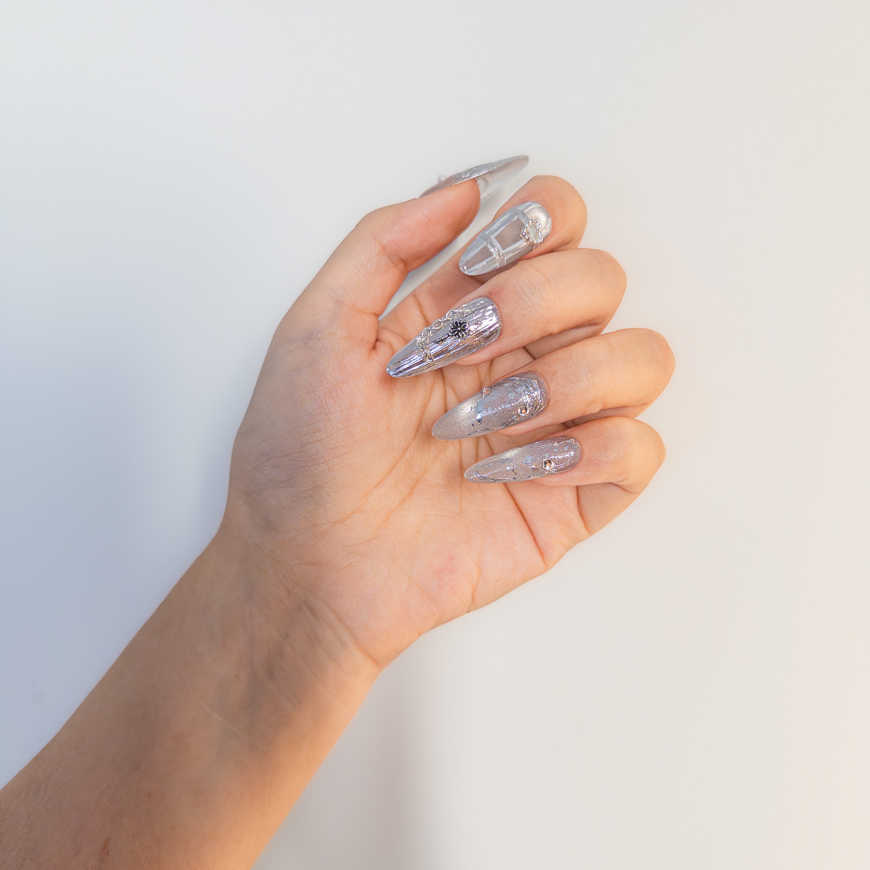 Molten silver chrome with 3D gothic chains and sculpted liquid metal details on durable salon-grade structure gel.