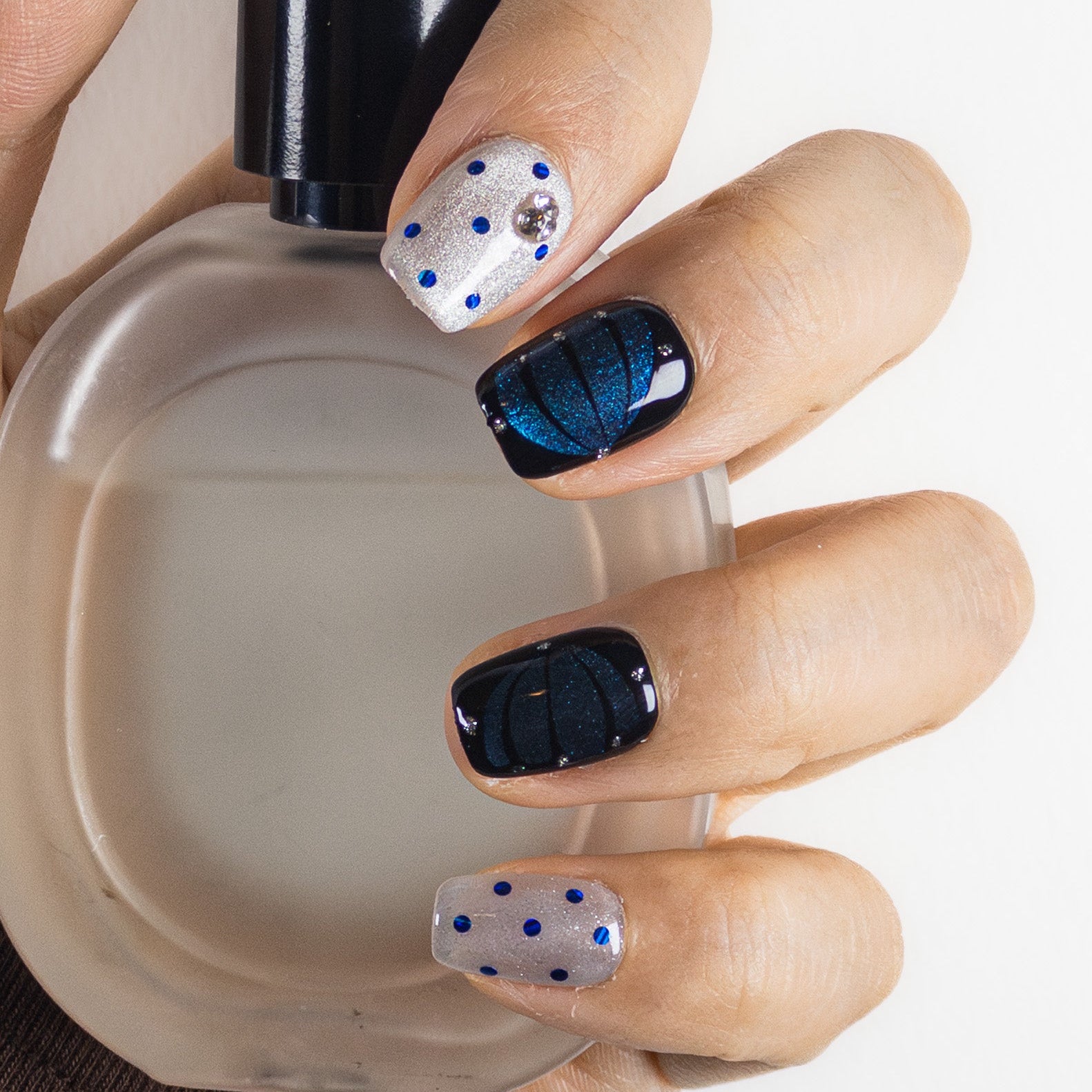 Lifestyle close-up showing high-gloss magnetic finish and smooth salon-grade structure against perfume bottle prop.