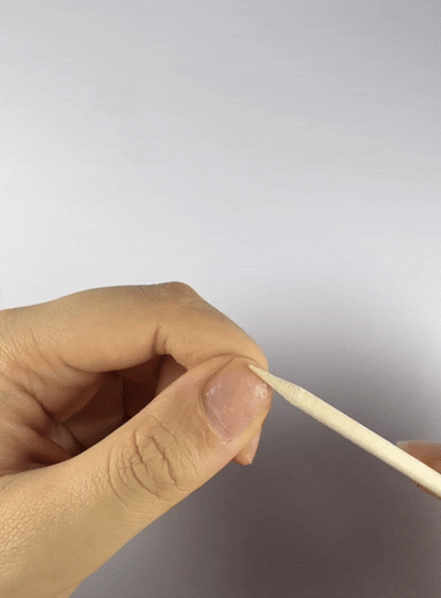 Gently peeling off the adhesive tab residue to make the Velvetkay nail ready for reuse.