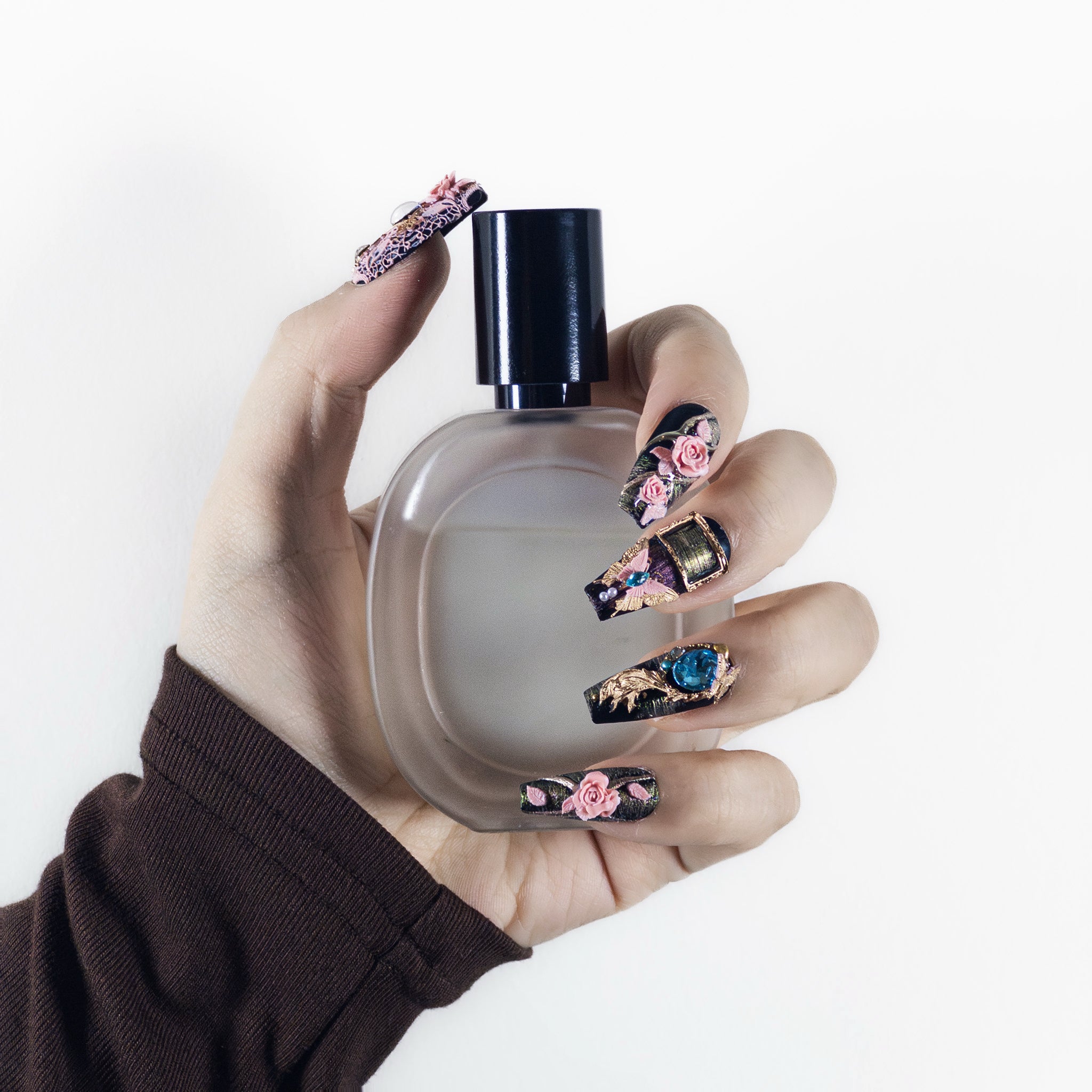 Close-up texture shot of Velvetkay Baroque Rose press-on nails in Coffin shape. Handcrafted ornate design detail.