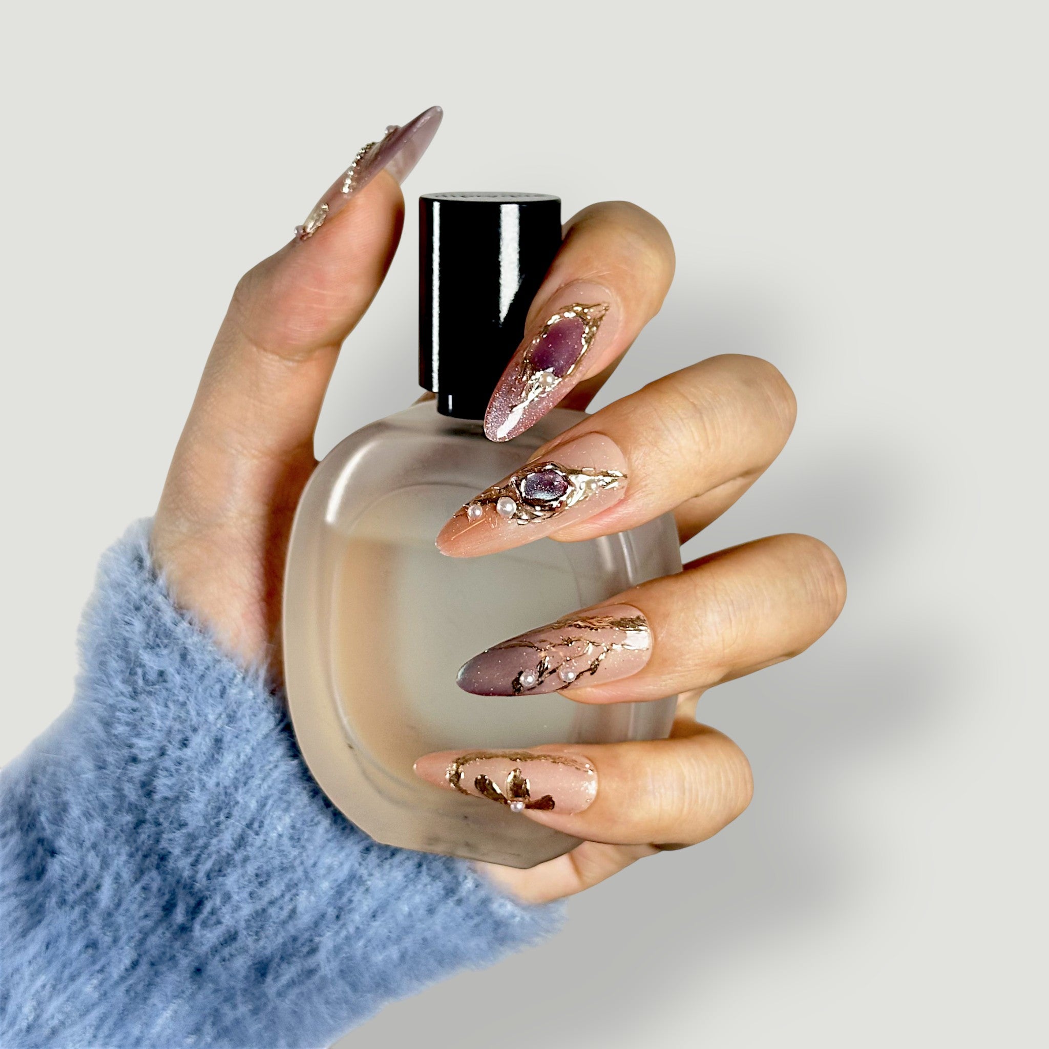 Side profile of Velvetkay Gilded Mirage nails, highlighting the golden accents and Almond silhouette.