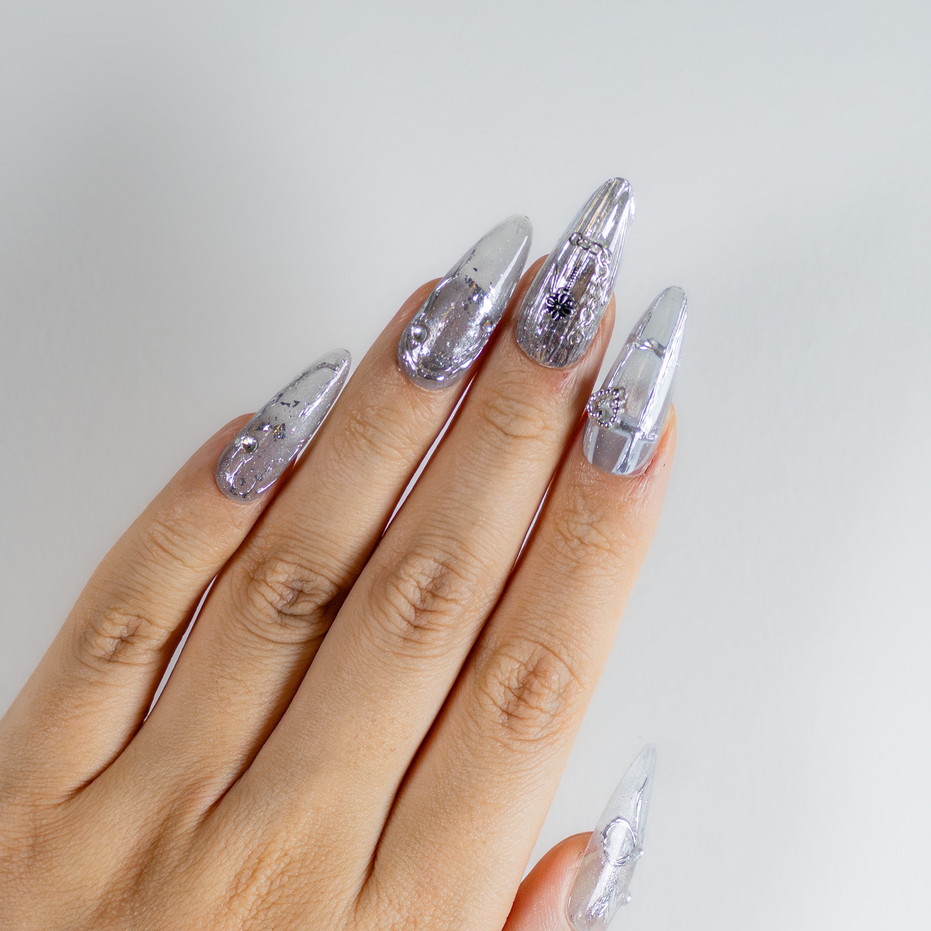 Molten silver chrome texture with 3D gothic cross charms and liquid metal details on handcrafted durable structured gel.