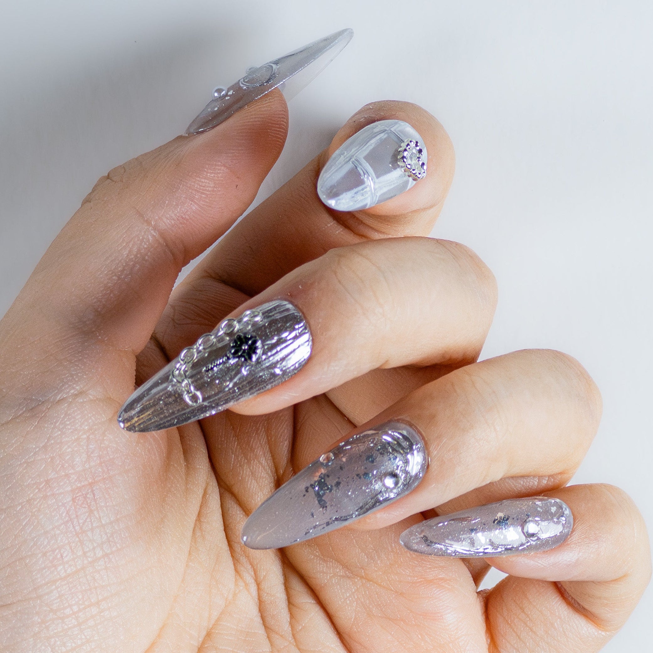 Molten silver chrome with 3D gothic chains and sculpted water droplets on durable salon-grade structure gel.