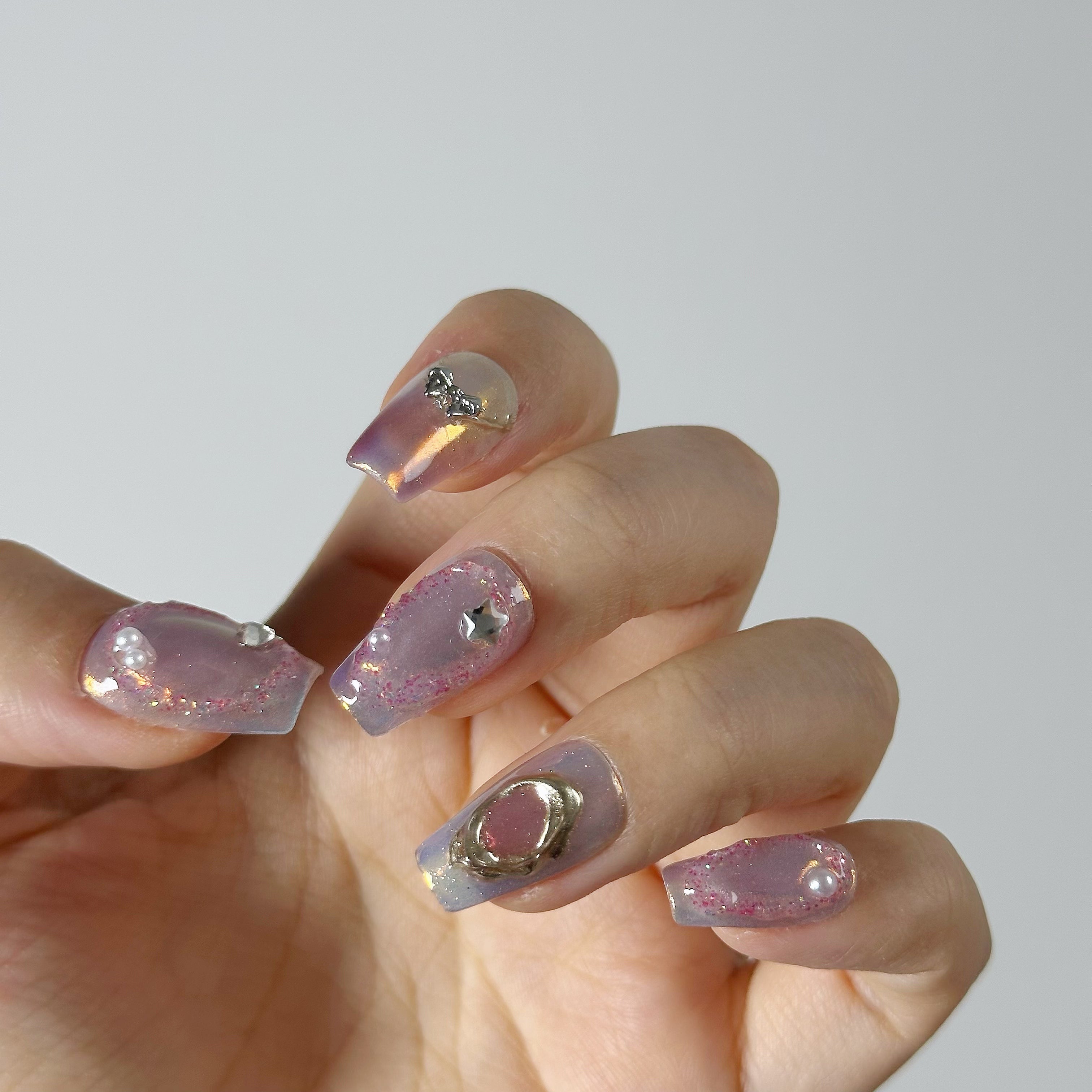 Translucent lavender aura art with 3D silver bow and planet charms on pink glitter textured structure gel.