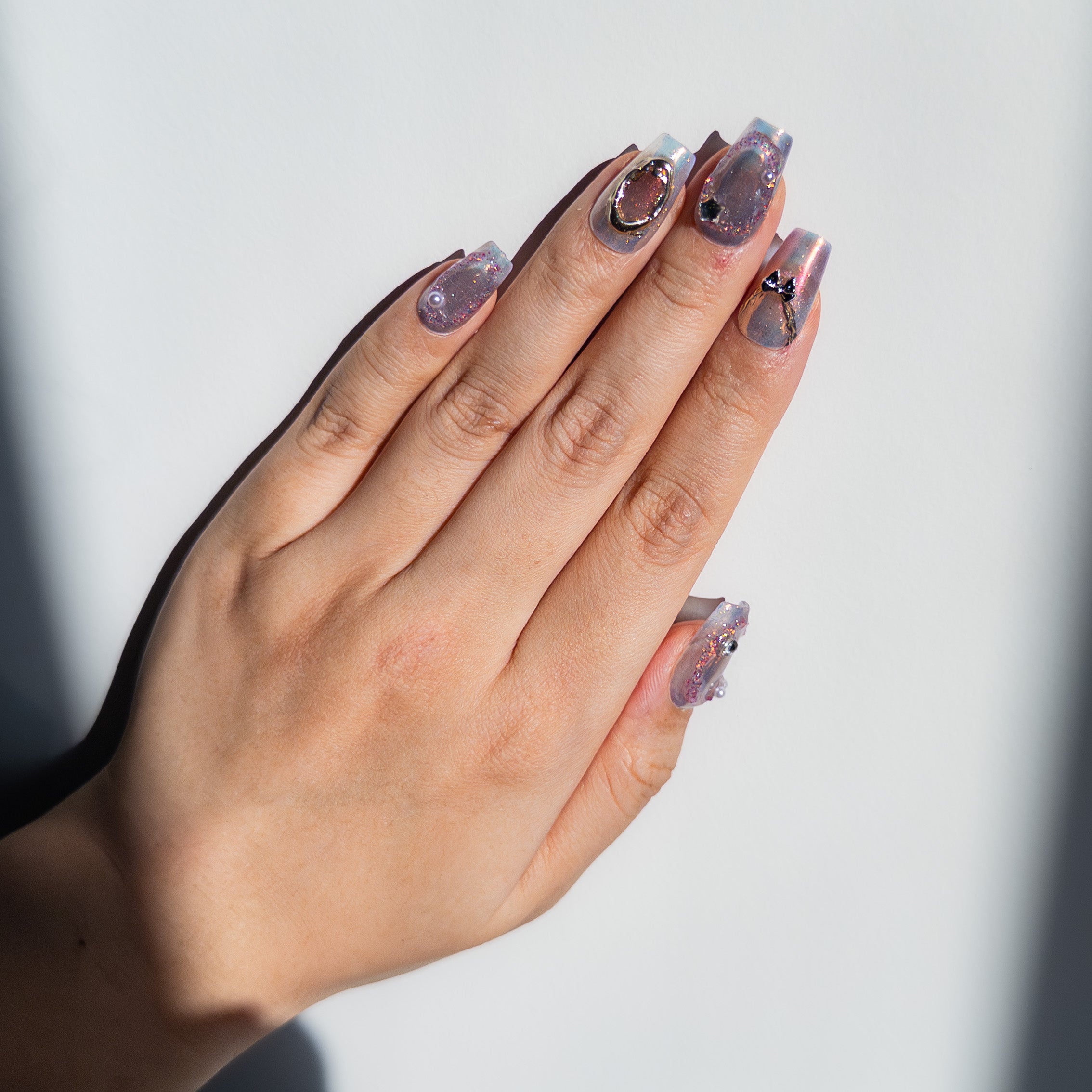 Glossy purple aura gradient and 3D silver hardware on luxury reusable structured gel coffin nails by Velvetkay.