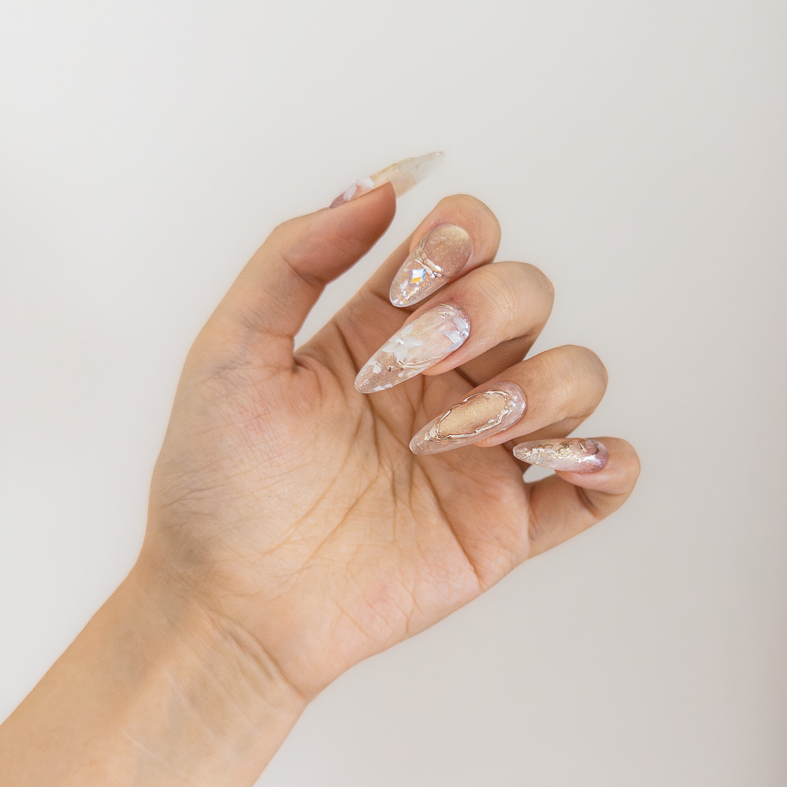 Translucent nude base with hand-painted gold textures on durable structure gel.